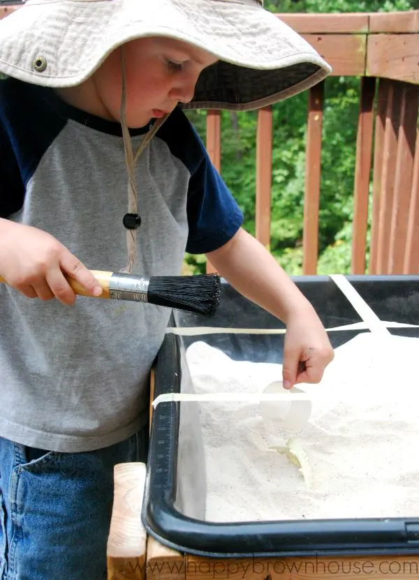 preschool sand table play digging for dinosaur bones