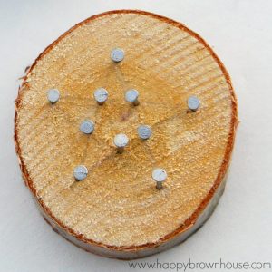 This rustic DIY Wood Slice String Art Ornament is simple to make and looks beautiful on the Christmas tree. Give as a gift or add to the top of a present for a creative giftwrap idea. Inspired by a Christmas children's book, this kid's Christmas ornament is perfect for fine motor skills practice.