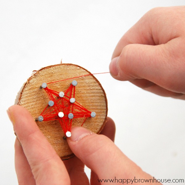 This rustic DIY Wood Slice String Art Ornament is simple to make and looks beautiful on the Christmas tree. Give as a gift or add to the top of a present for a creative giftwrap idea. Inspired by a Christmas children's book, this kid's Christmas ornament is perfect for fine motor skills practice. 