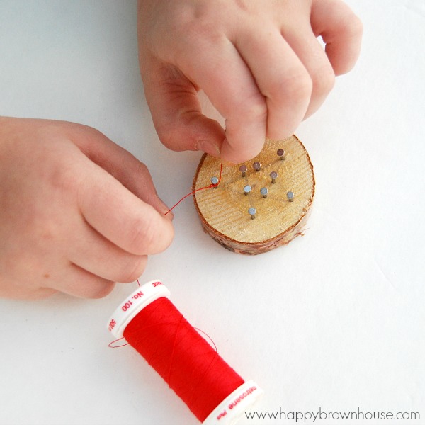 This rustic DIY Wood Slice String Art Ornament is simple to make and looks beautiful on the Christmas tree. Give as a gift or add to the top of a present for a creative giftwrap idea. Inspired by a Christmas children's book, this kid's Christmas ornament is perfect for fine motor skills practice. 