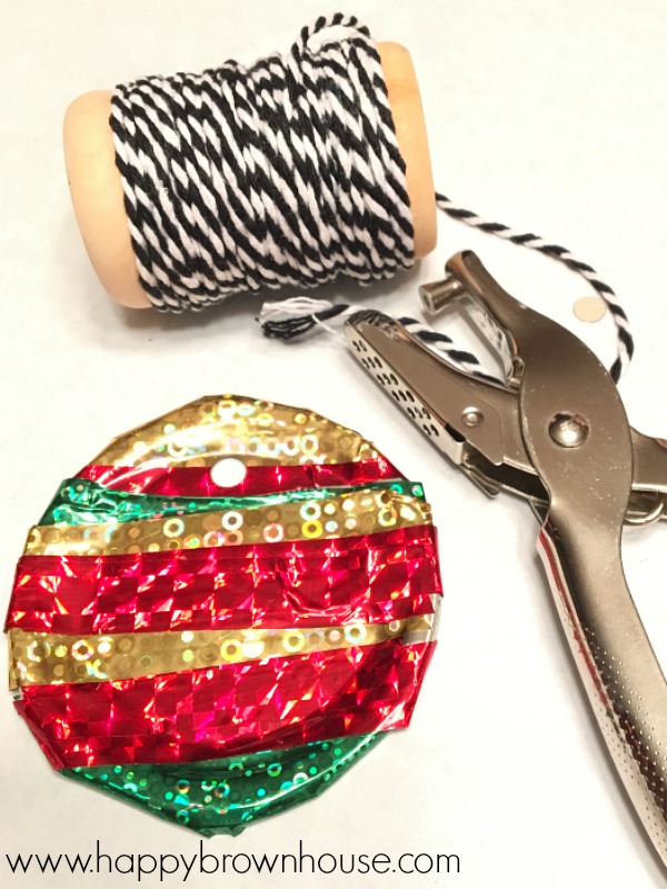 This Kid-Made Washi Tape Mason Jar Lid Ornament is adorable and so simple to make for Christmas. This homemade ornament is perfect for working on fine motor skills. The best part is I already have all the mason jar lids and washi tape for this kids Christmas ornament craft.