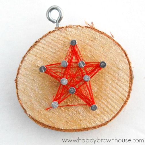 This rustic DIY Wood Slice String Art Ornament is simple to make and looks beautiful on the Christmas tree. Give as a gift or add to the top of a present for a creative giftwrap idea. Inspired by a Christmas children's book, this kid's Christmas ornament is perfect for fine motor skills practice. 