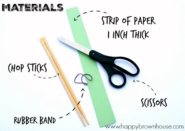 Materials needed to make DIY Fine Motor Tongs made with Chopsticks: chopsticks, rubber band, strip of paper 1 inch thick, scissors