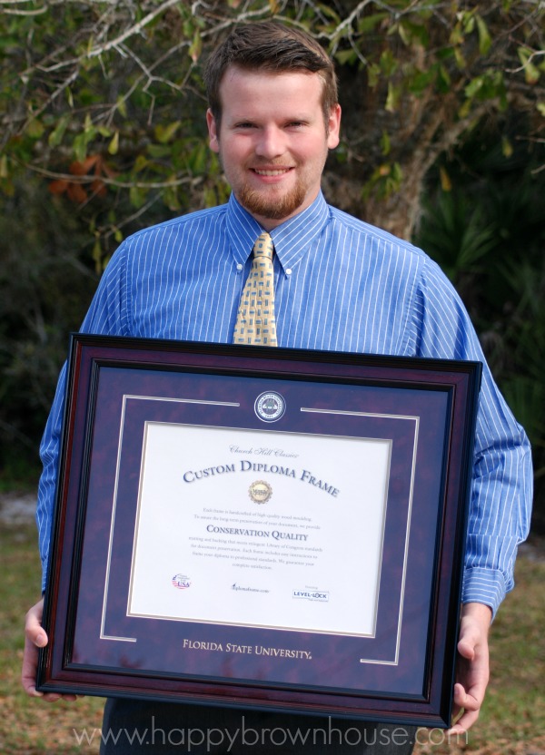 Young man holding a Custom Diploma Frame from Church Hill Classics given as a college graduation gift