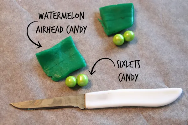 candy ingredients for homemade peapod cupcake toppers, watermelon airhead candy and green sixlets candy, knife