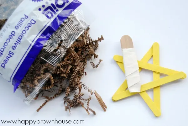 Use brown shredded paper resemble hay for a Nativity Star Ornament