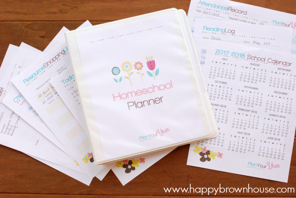 white notebook and printable homeschool planner pages scattered on a brown background