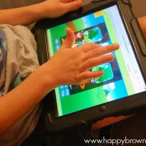 close up of iPad screen and child's hands playing the Reading Eggs game