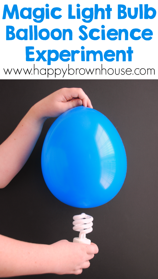 child's left hand holding a blue balloon over a light bulb with the right hand, black background