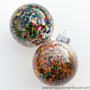 Two glass ornament balls filled with colorful crayon shavings that have been melted inside the ornament