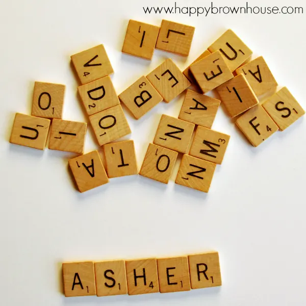 Let the kids help make this easy, personalized Scrabble Tile Name Christmas Ornament. Perfect kids Christmas craft for preschoolers learning how to spell their name. Book-inspired ornament that pairs well with the book, Santa's Book of Names. #KidMadeChristmas