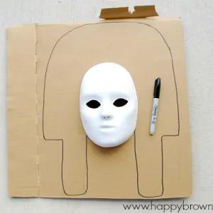 beginning step of making a King Tut Burial Mask with kids, draw shape on cardboard