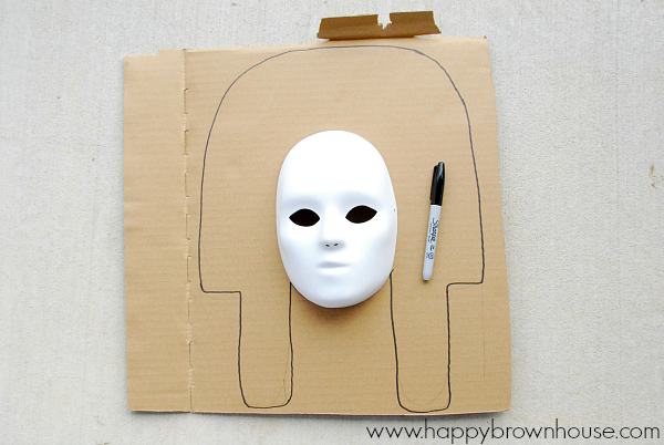 beginning step of making a King Tut Burial Mask with kids, draw shape on cardboard