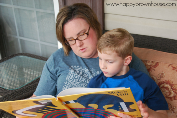 Mother with a child on her lap reading a yellow book