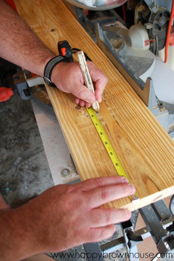 Close up of man\'s hands measuring wood to mark for a cut