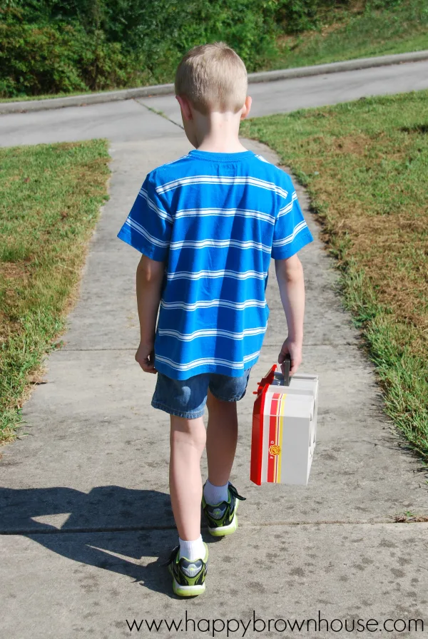 Boy walking with portable PLAYMOBIL Take Along Fire Station