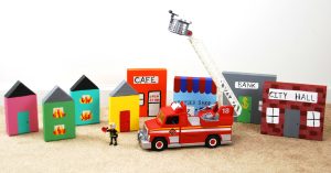 This DIY Wooden Block Town is the perfect homemade gift to accompany your child's favorite rescue vehicles. Kids will love engaging in imaginative play as they pretend to put out fires and rescue the town. See how one mom pairs the town with the PLAYMOBIL Take Along Fire Station and Rescue Ladder Unit for the ultimate pretend play experience. #PlayWithPlaymobil #pretendplay #kids #crafts #kidcrafts #imagination