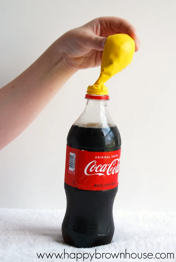 Pouring candy into a soda bottle for the Soda and Candy Balloon Science Experiment for kids