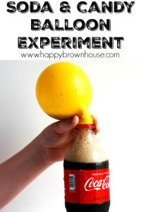 close up of a yellow balloon partially inflated and attached to a Coke bottle for a soda and candy balloon science experiment