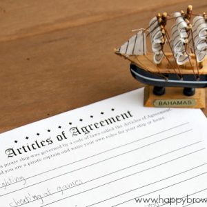 Close up of a free printable Articles of Agreement and a small pirate ship figurine