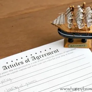 Close up of a free printable Articles of Agreement and a small pirate ship figurine