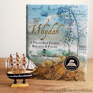 Close up of The Whydah book and a small pirate ship figurine