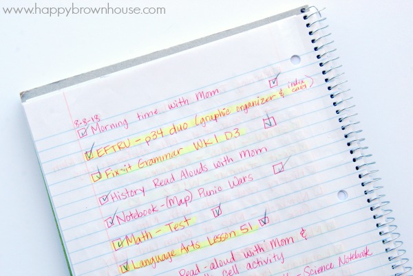 Close up of a handwritten homeschool assignment notebook with their daily activities and assignments listed and highlighted