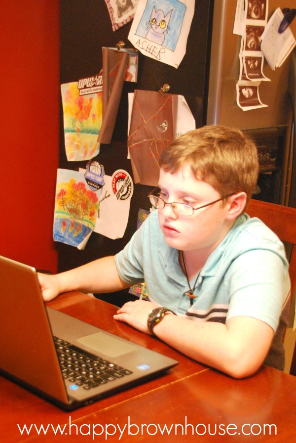 boy with glasses looking at a computer screen
