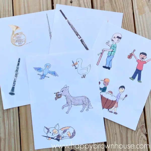 Papers fanned out with Peter and the Wolf cartoon characters and instrument pictures on them to use with Peter and the Wolf classical music story with Clap for Classics online musical courses.