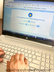 close up of laptop screen and keyboard with child's hands